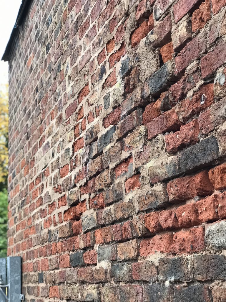 This image shows the damage caused to soft handmade bricks by cement pointing